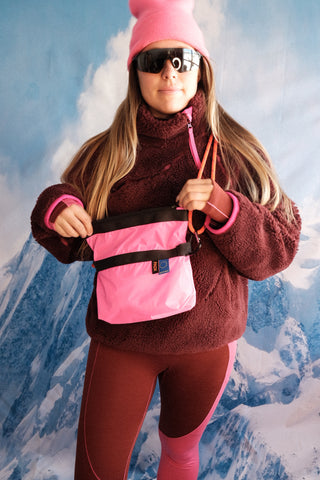 SENIQ model Tina wears Half Baked Fleece Pullover in Moody with Cabin Fever Merino Wool Leggings for insulated warm weather gear that's cozy and vibrant for ski snowboard outerwear with Packbags Crossbody.