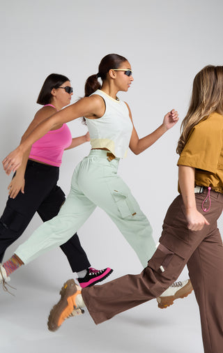 Group of women jumping in SENIQ technical outdoor clothing. Trailmix Pant with Field Crop