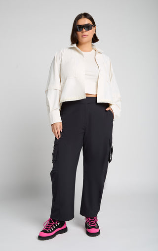 Woman wearing outdoor technical gear designed by SENIQ. Field Crop Tank, Trailmix Pant, Dirtpop Trek Jacket. lightweight, durable, 4-way-stretch pant.
