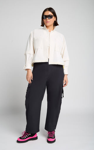 Woman wearing outdoor technical gear designed by SENIQ. Field Crop Tank, Trailmix Pant, Dirtpop Trek Jacket. lightweight, durable, 4-way-stretch pant.