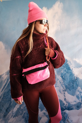 SENIQ model Tina wears Half Baked Fleece Pullover in Moody with Cabin Fever Merino Wool Leggings for insulated warm weather gear that's cozy and vibrant for ski snowboard outerwear with Packbags Crossbody.