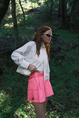 Woman outdoors wearing SENIQ Trailmix Short, Dirtpop Trek Jacket, and Oasis Tank