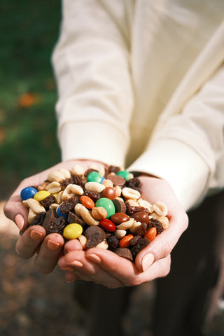 Women holding trailmix in hands, descriptive of SENIQ's philanthropic missions