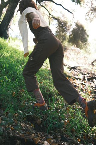 Woman hiking uphill wearing SENIQ Trailmix Pants