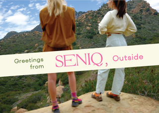 SENIQ Letter from Founders Postcard, women in outdoor gear looking onto mountain landscape