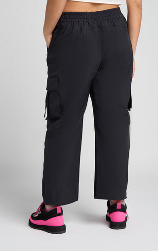Woman wearing outdoor technical gear designed by SENIQ. Field Crop Tank, Trailmix Pant. lightweight, durable, 4-way-stretch pant.